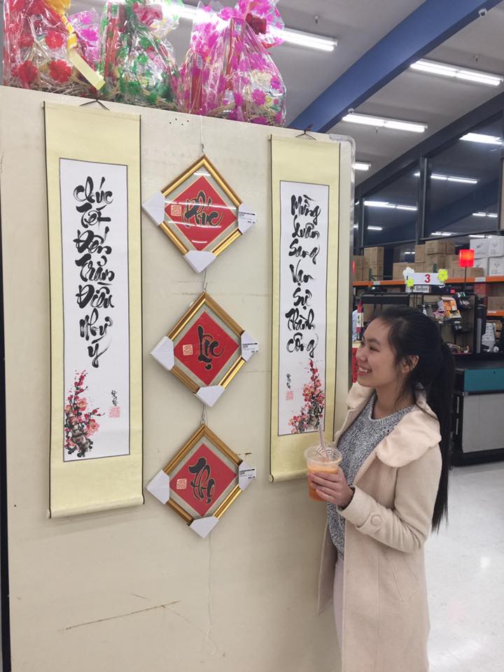 Cô gái đang thưởng lãm thư pháp ngày xuân tại chợ Hồng Phát ở Oregon, Mỹ.