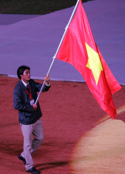 người vinh hạnh cầm cờ đẫn đầu là vận động viên điền kinh Nguyễn Duy Bằng (ảnh).